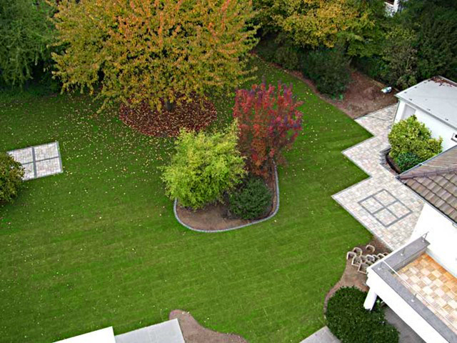 Neugestaltete Gartenanlage mit Rasen, Beeten und Terrasse